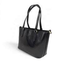 Black leather handbag, front view from the right, House of Enira Isual