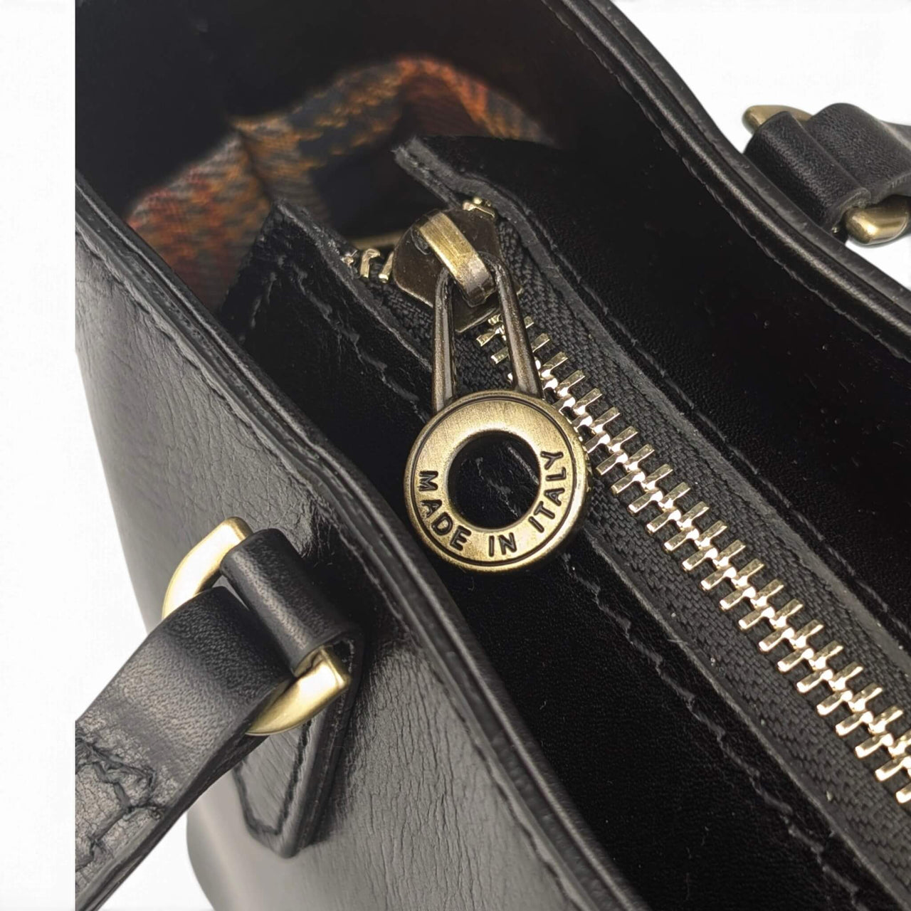 Black leather handbag, close-up of the top zip, House of Enira Isual