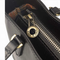 Black leather handbag, close-up of the top zip, House of Enira Isual