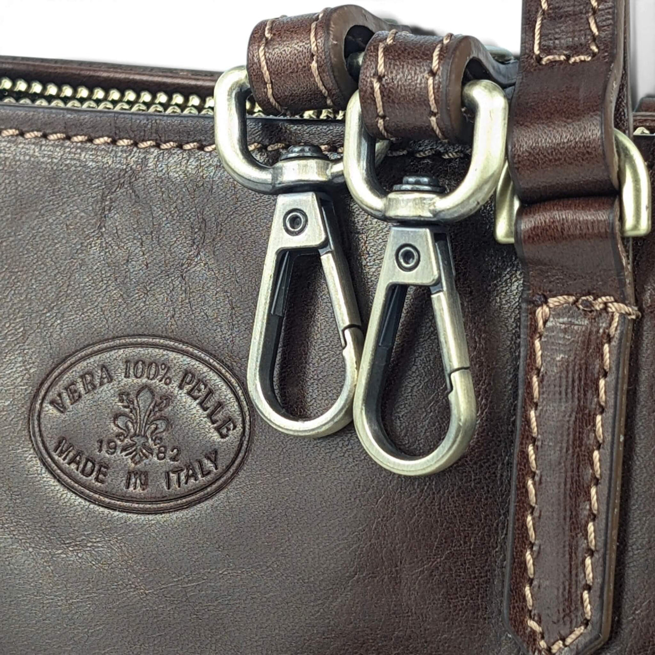 Handtasche aus dunkelbraunem Leder, Nahaufnahme von Beschlägen und Vera-Pelle-Prägung, House of Enira Isual