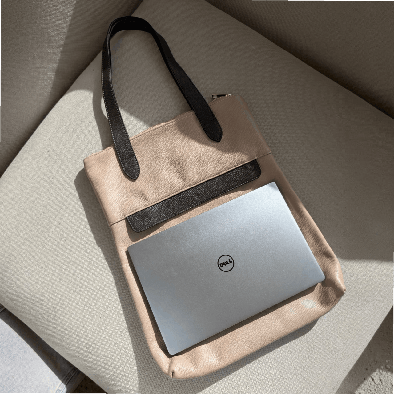13-inch laptop lying horizontally on top of the dusty pink Liali pebbled leather shopper, House of Enira