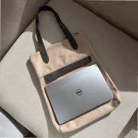 13-inch laptop lying horizontally on top of the dusty pink Liali pebbled leather shopper, House of Enira