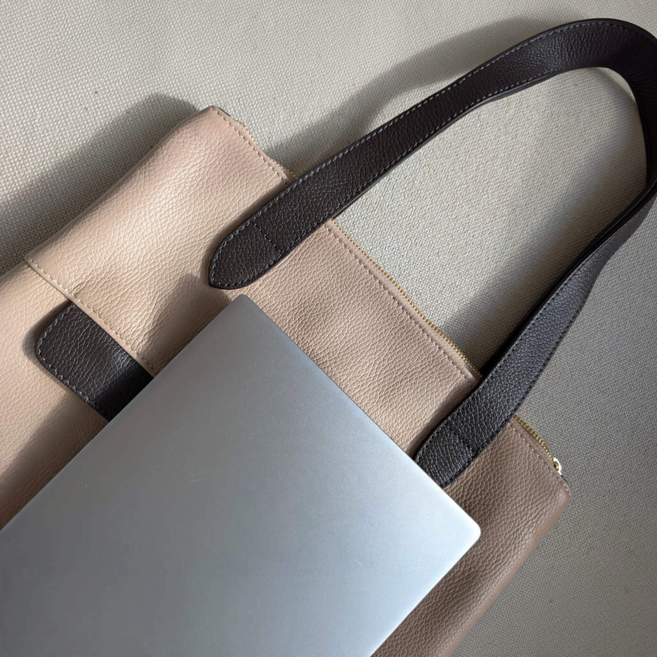 Close-up of a 13-inch laptop on top of the dusty pink Liali pebbled leather shopper, House of Enira