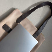 Close-up of a 13-inch laptop on top of the dusty pink Liali pebbled leather shopper, House of Enira