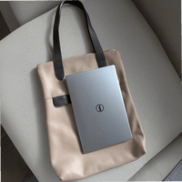 13-inch laptop lying vertically on top of the dusty pink Liali pebbled leather shopper, House of Enira