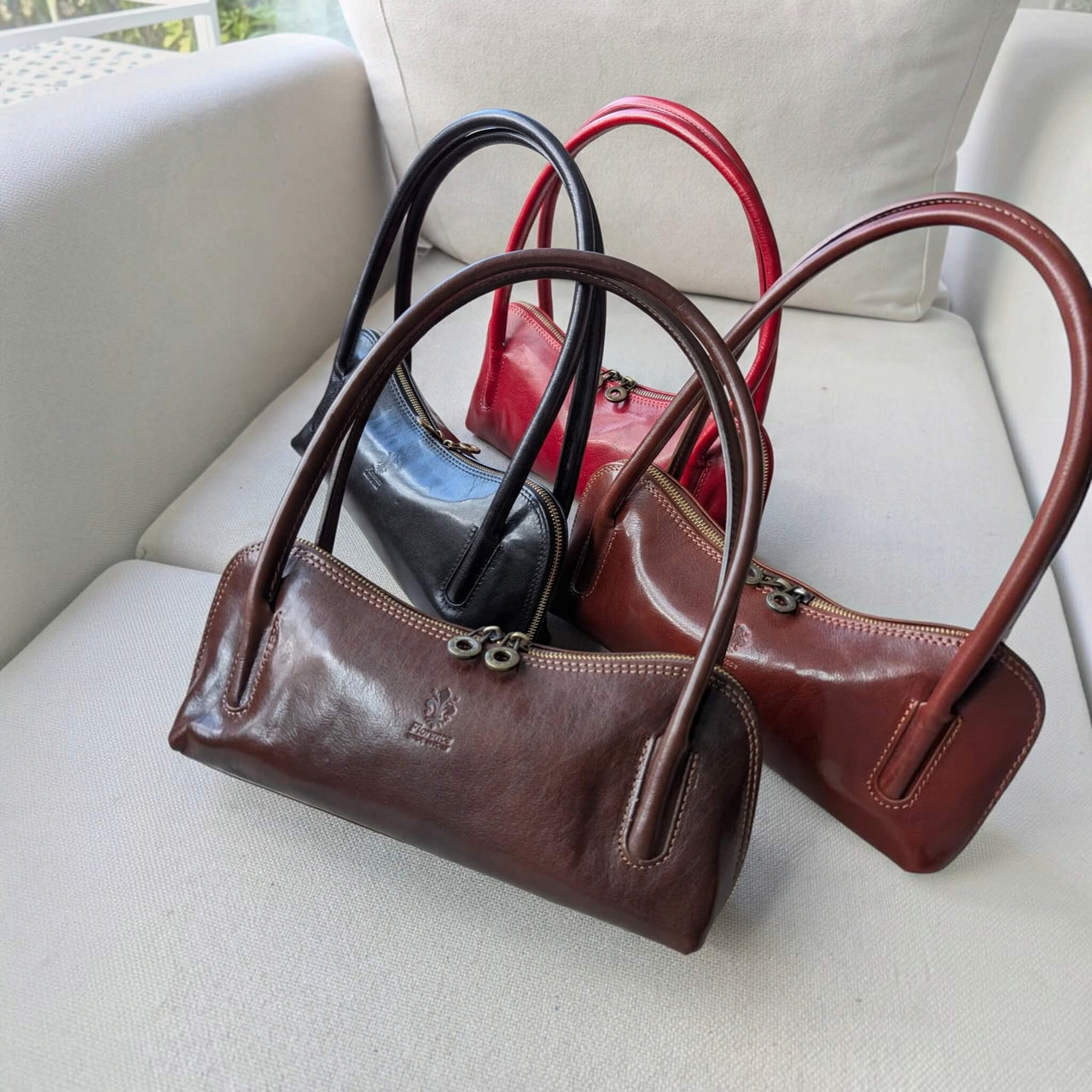 Viali baguette bags in black, chocolate, dark marron and red on a sofa, House of Enira