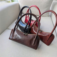 Viali baguette bags in black, chocolate, dark marron and red on a sofa, House of Enira