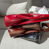 Viali baguette bags in black, taupe, chocolate and dark marron stacked on top of each other, House of Enira