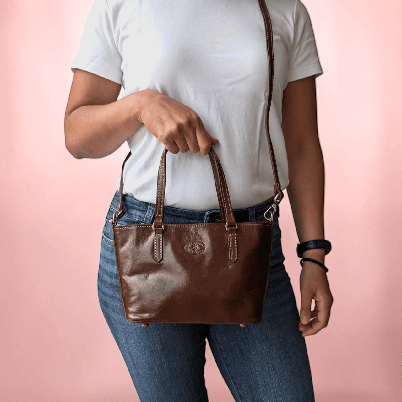 Handtasche aus Leder in Schokobraun, am Tragegriff gehalten