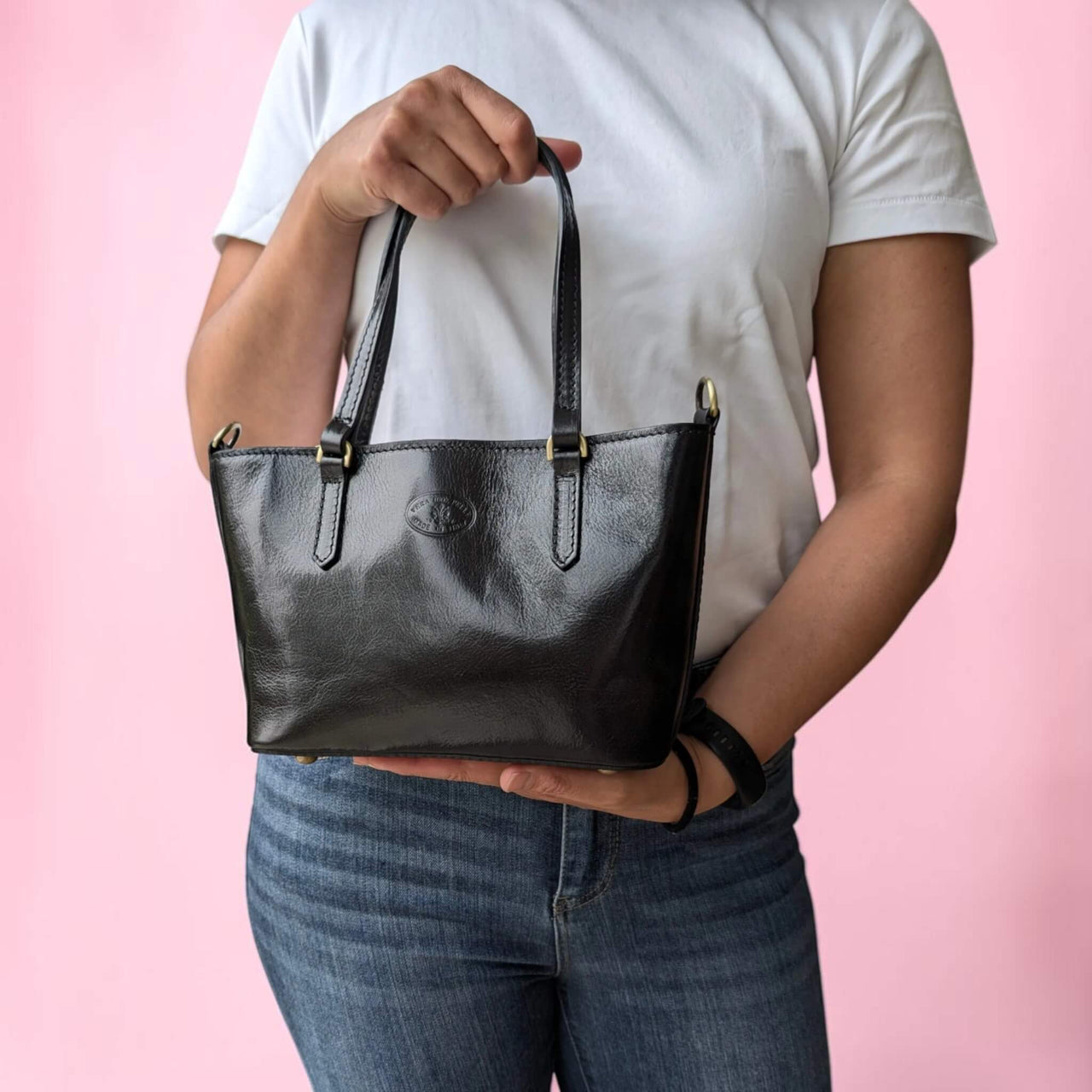 Black leather handbag, held by our model