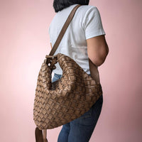 Dark taupe woven leather shoulder bag, worn on one shoulder as a backpack