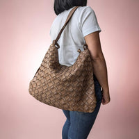 Dark taupe woven leather shoulder bag, carried on the shoulder by our model, House of Enira Licea
