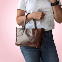 Handtasche aus Leder in dunklem Kastanienbraun, in der Armbeuge getragen