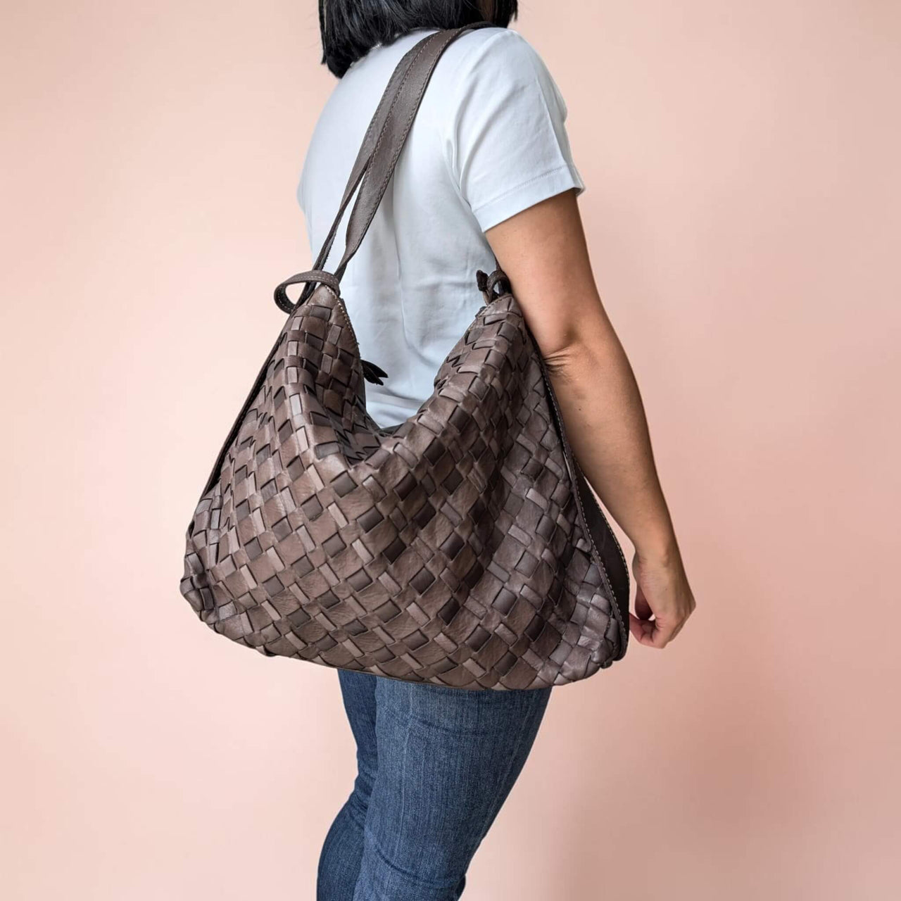Schultertasche aus geflochtenem Leder in Schokobraun, vom Model über der Schulter getragen