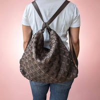 Schultertasche aus geflochtenem Leder in Schokobraun, vom Model als Rucksack getragen