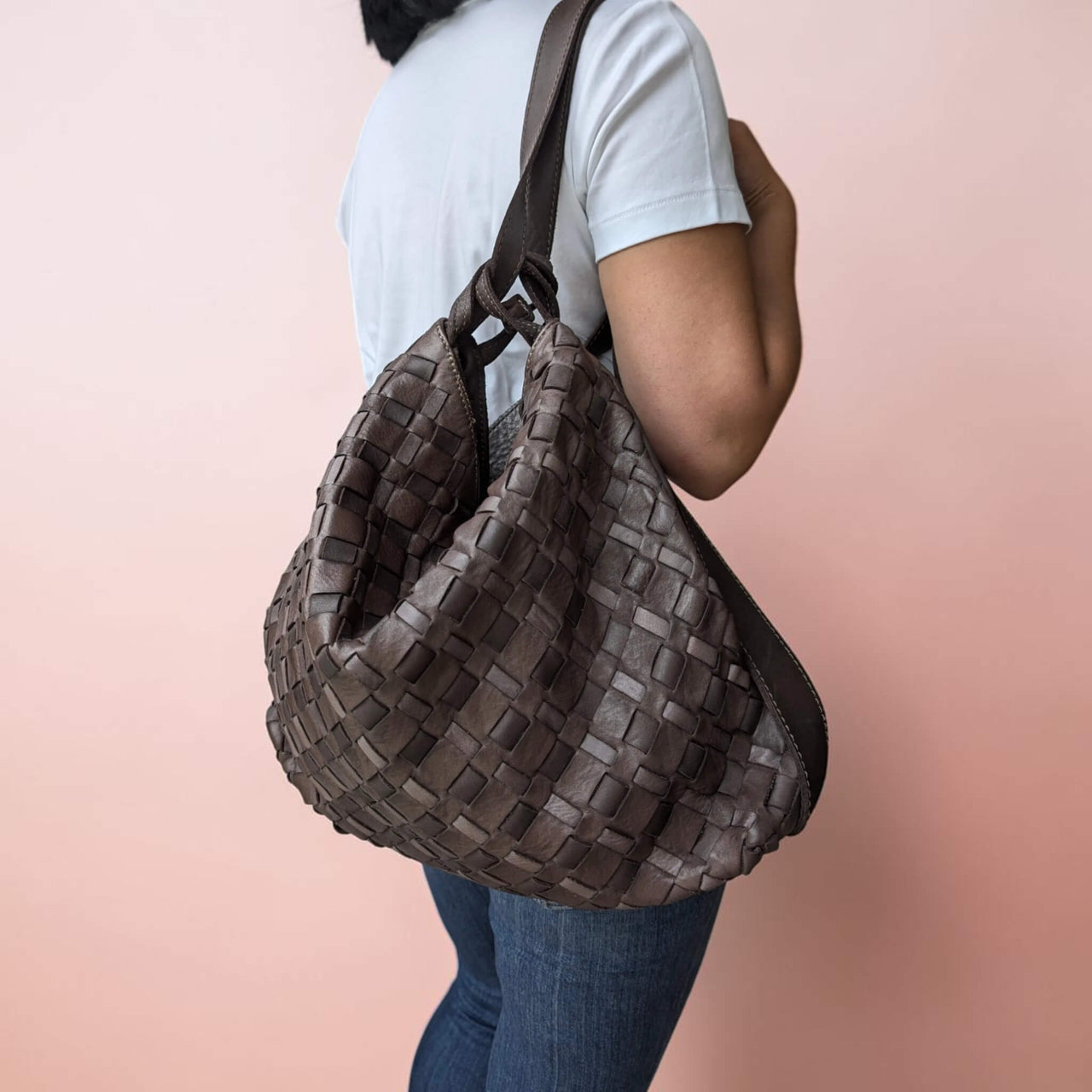Schultertasche aus geflochtenem Leder in Schokobraun, auf einer Schulter als Rucksack getragen