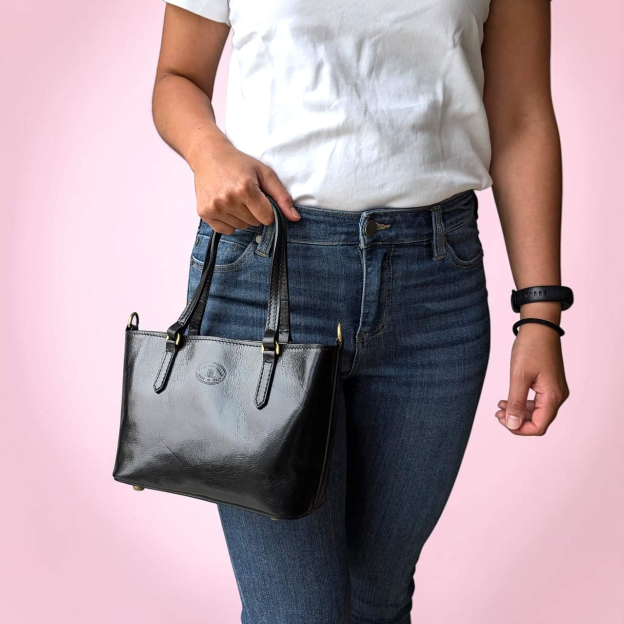 Black leather handbag, held by the top handles, House of Enira Isual