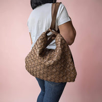Dark taupe woven leather shoulder bag, worn as a backpack by our model