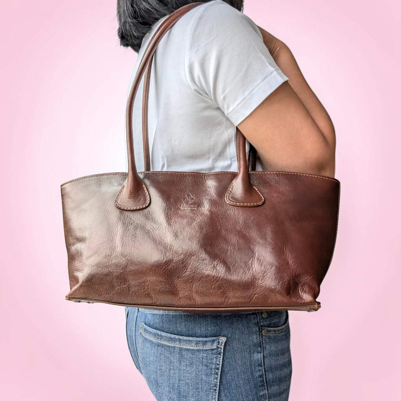 Dark marron brown leather shoulder bag, carried on the shoulder by our model, House of Enira Miacal